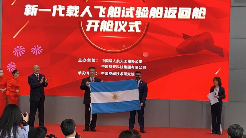 Entrega de una bandera argentina tras su travesía espacial
