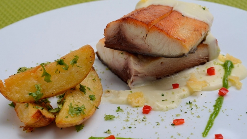 Pacú a la parrilla con papas crocantes a las hierbas frescas y salsa de limones asados